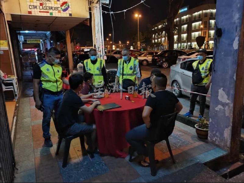 
警员在餐饮店检查聚餐的民众。