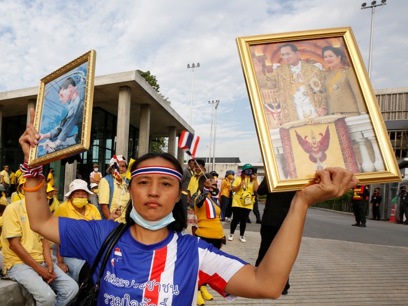 保皇派阵营在国会外示威集会期间，一名示威者高举已故泰王普密蓬夫妇和现任泰王哇集拉隆功的肖像。（欧新社照片）