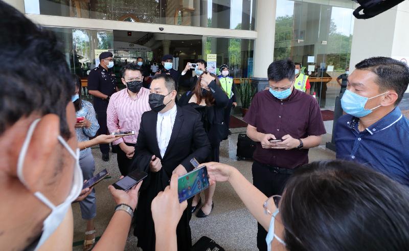 律师萧俊仁（中）在法庭外向媒体及农民简报申请司法审核的进展。