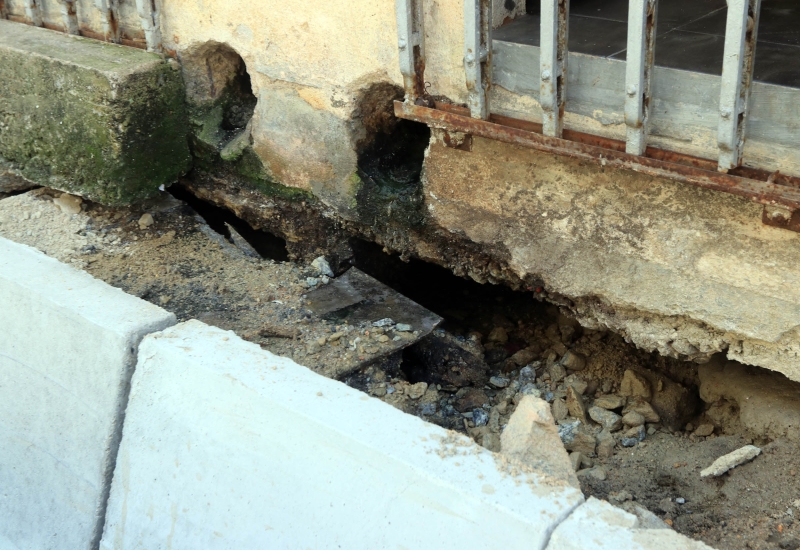 相信是泥石流失，导致店屋与地面之间出现裂缝。
