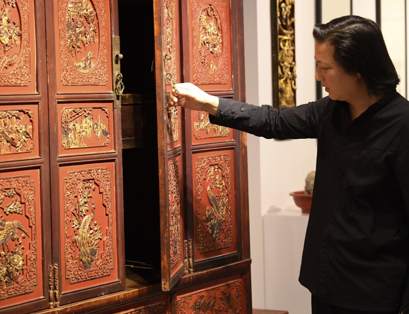 浙江省工艺美术大师陈国华在工作室介绍其收藏的老木雕家具。

