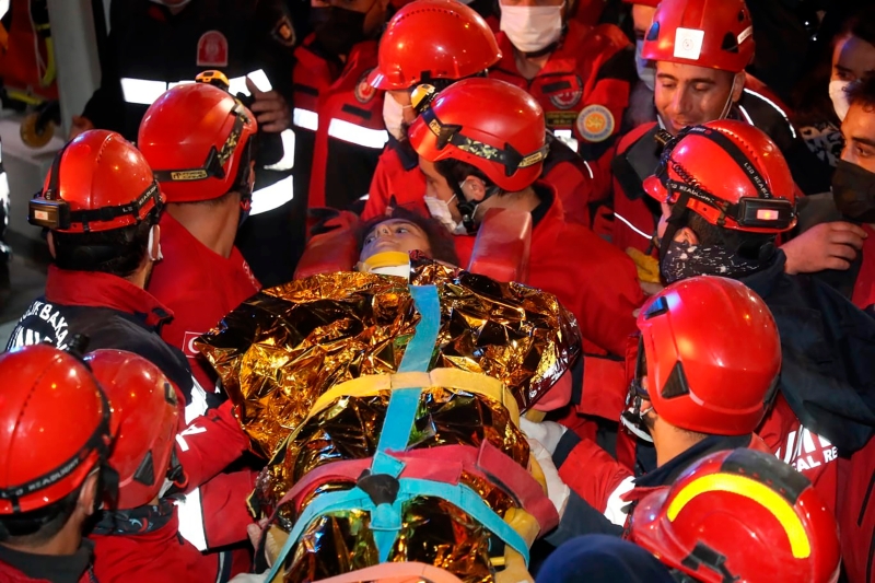 伊斯坦布尔通讯社释出的现场照片显示，救援人员用金色铝箔保温毯裹着少年。（美联社照片）