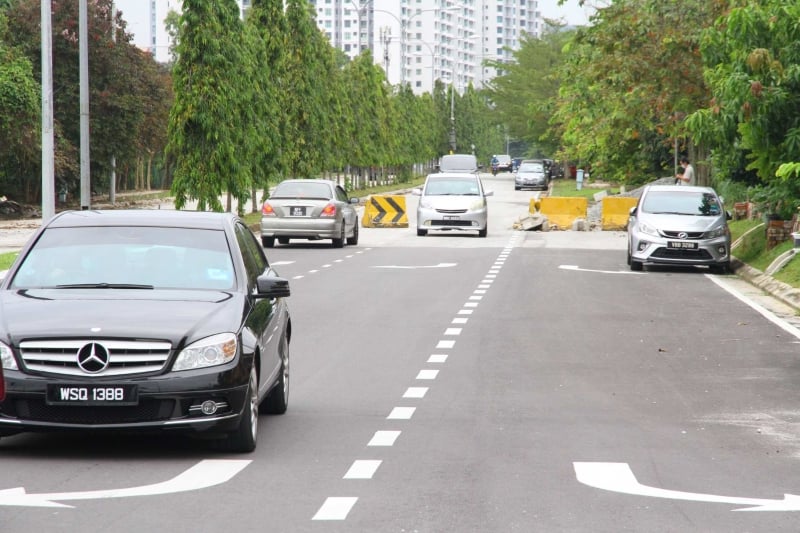 居民擅自移开石墩使用未开放的新道路，以缩短路程。