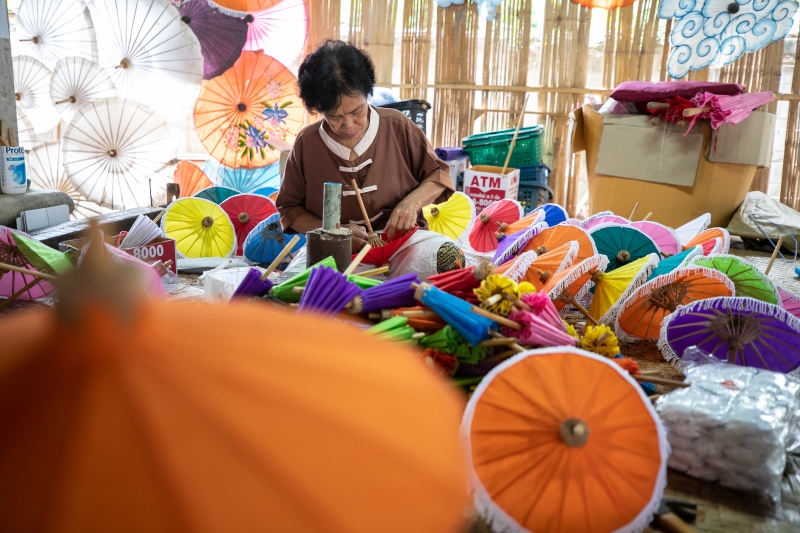 一名女工匠在泰国清迈市博桑伞村的纸伞制作中心粘贴伞面。　　

