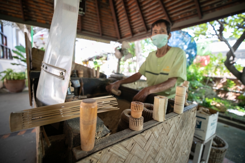 工匠在泰国清迈市博桑伞村的纸伞制作中心制作伞柄。

