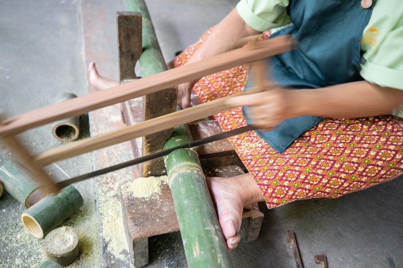 女工匠以手工处理纸伞伞骨。　

