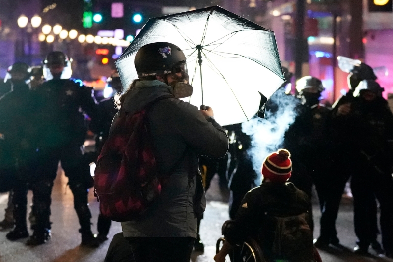 一名示威者用雨伞挡住警方发射的催泪弹。