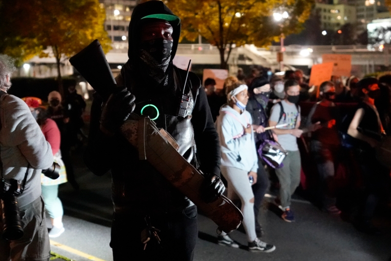 一名示威者佩带枪械参加游行。