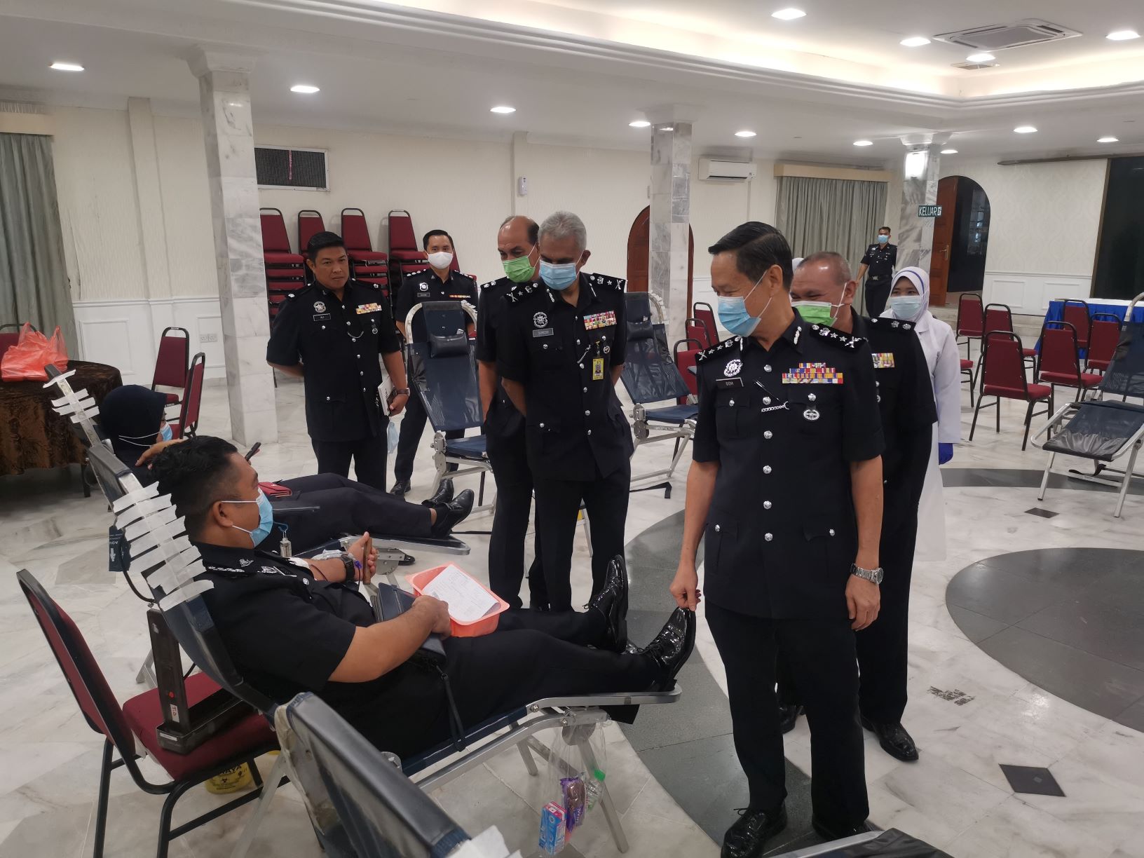 吴文恭（右一）巡视捐血运动场地，并和捐血中的警员寒暄。