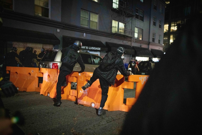 在波特兰，示威者为了逃避警察的追捕，跳过警方设立的屏障。 