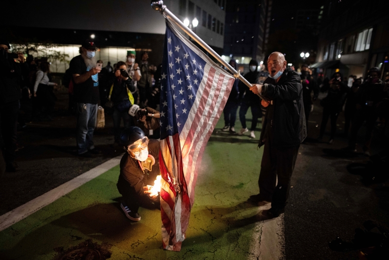 一名示威者焚烧美国国旗泄愤。