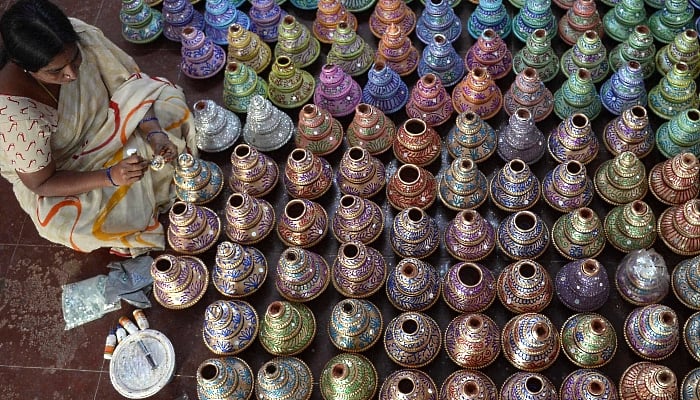 An artisan displays earthenware oil pots or diya ahead of Diwali, the Hindu festival of lights, at a workshop in Hyderabad, India. AFP An artisan displays earthenware oil pots or diya ahead of Diwali, the Hindu festival of lights, at a workshop in Hyderabad, India. AFP