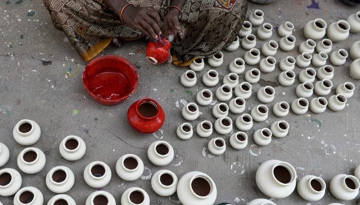 An artisan applies colors on earthenware oil pots or diyas ahead of Diwali, the Hindu festival of lights, at a workshop in Hyderabad, India. AFP An artisan applies colors on earthenware oil pots or diyas ahead of Diwali, the Hindu festival of lights, at a workshop in Hyderabad, India. AFP
