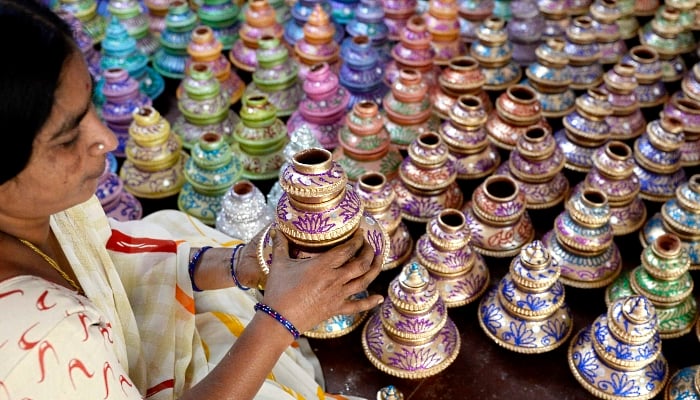 An artisan displays earthenware oil pots or diya ahead of Diwali, the Hindu festival of lights, at a workshop in Hyderabad, India. AFP An artisan displays earthenware oil pots or diya ahead of Diwali, the Hindu festival of lights, at a workshop in Hyderabad, India. AFP
