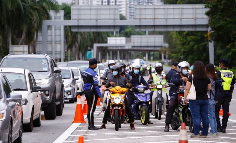 警方截查每名摩托车骑士，记者在旁采访。

