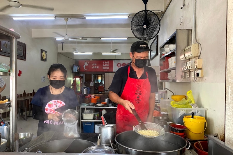 余爱晶（左）与张孙光（右）各司其职，分别负责烫酿豆腐及煮面。