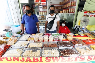 在吉隆坡小印度一带的印度档口，摆卖的甜食（Sweets）和小吃（Snacks）多达数十种，可说是麻雀虽小，五脏俱全。左为Patiala Punjabi Sweets业主Raju。