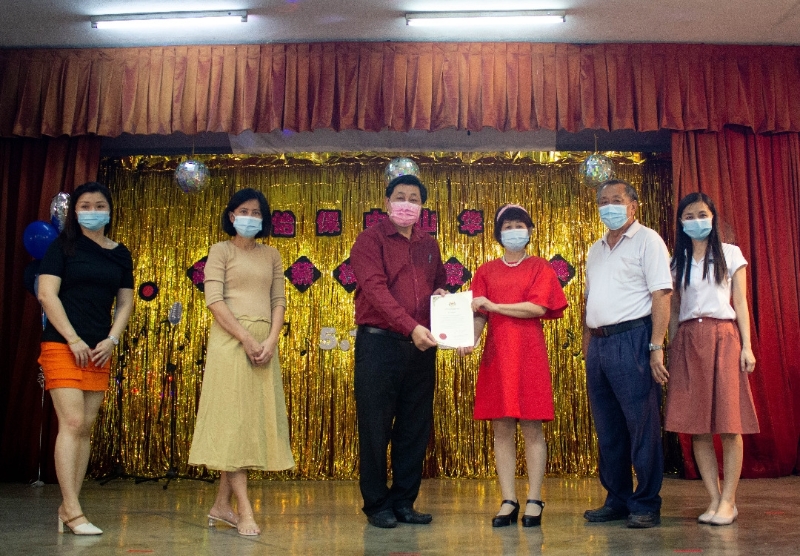 黄仲贤（左三）颁发荣休证书给简淑燕（右三）。左起是陈绣芸、江秀洁；右起是张苑珠、温炳楠。