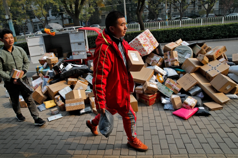 双11网购季，也是快递小哥最忙录的时间，在北京一处小区路口，网购货品堆满一地，让民众自行领取。（美联社照片）