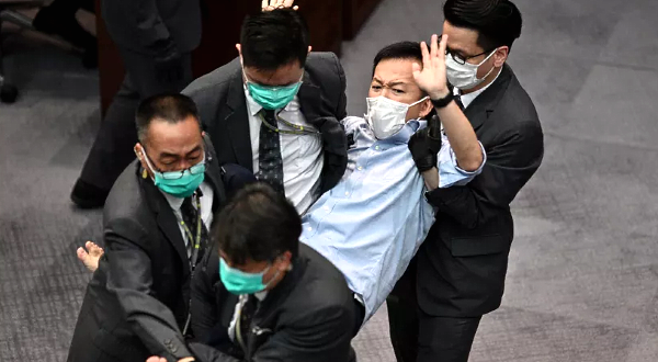Pro-democracy lawmaker Raymond Chan was carried away by security following scuffles with pro-Beijing lawmakers at the Legislative Council in May. AFP