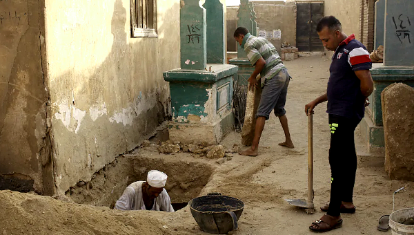 A caretaker digs a grave. Although older than 1,000 years, the cemetery remains active. A caretaker digs a grave. Although older than 1,000 years, the cemetery remains active.