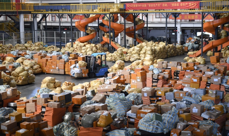 在中国邮政集团广州航空邮件处理中心里，工作人员借助分拣设备加紧作业，保障双十一高峰期的物流正常运转。（图：新华社）