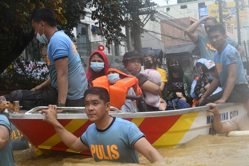 救护员出动救生艇，将灾民带离灾区。（图：法新社）