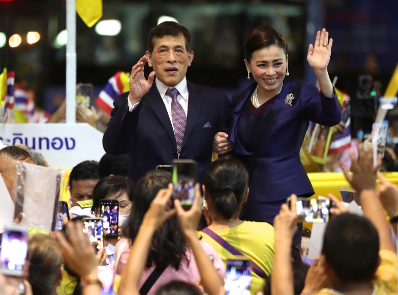 泰王和王后上周六傍晚在曼谷郊区主持新地铁延线开通仪式后，与现场的保王派支持者亲切互动。（美联社照片）