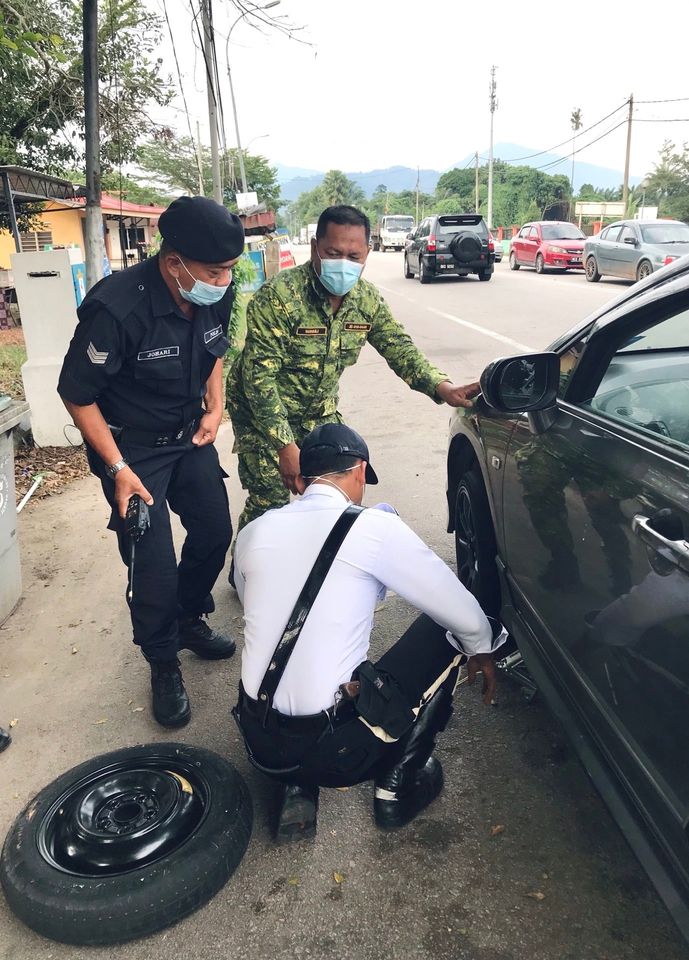来自东甲的交警人员和志愿警卫队员在路障发现一名女司机的车胎漏气，当场施予援手换轮胎。