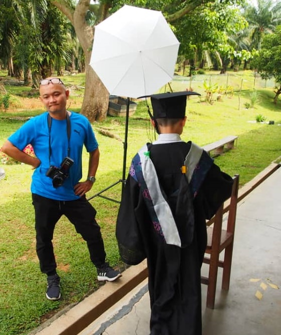 陈国辉很有耐心的为毕业生拍个人毕业照。