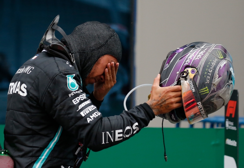 在F1土耳其站以冠军完赛，提前锁定7度车手世冠后，汉密尔顿一度掩眼沉思，似乎情绪激动。（美联社照片）