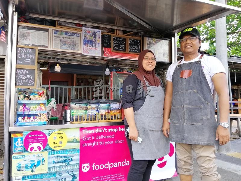 诺希山（右起）与妻子哈希玛在槟城中央医院旁的街边，经营炸鸡排生意。