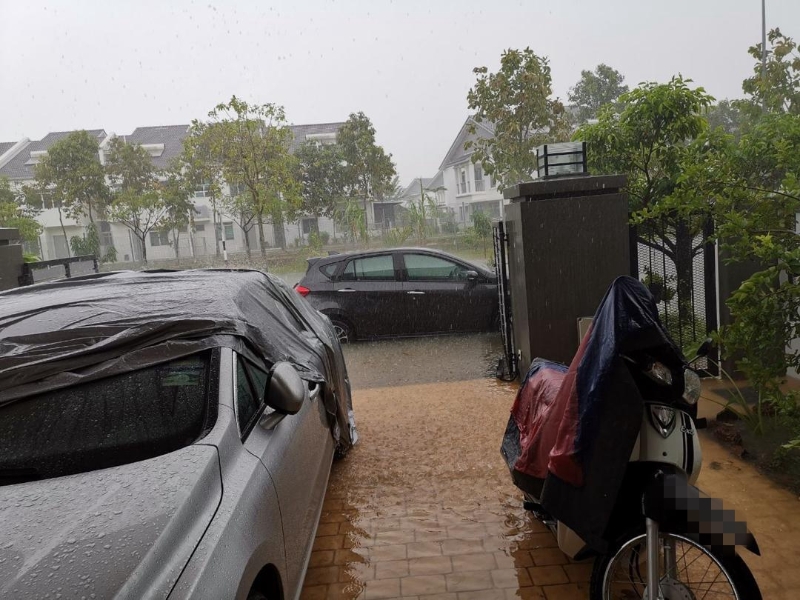 王小姐拍下的照片显示，急剧的骤雨使得沟水溢出，淹入其民宅车房。