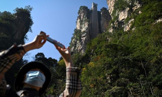 Tourists can zip up the cliff in just 88 seconds, or brave a 3-hour climb to the top. AFP