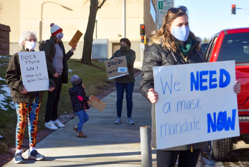 美国南达科他州苏瀑市的民众周一在市政厅外面举牌示威，要求市议会立即实施强制口罩令。（美联社照片）

