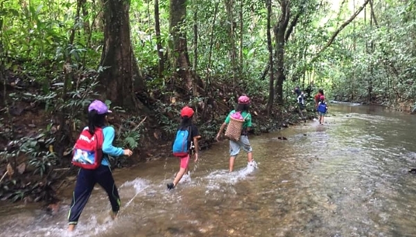 The children have to cross a small river to reach the area with WiFi signals.