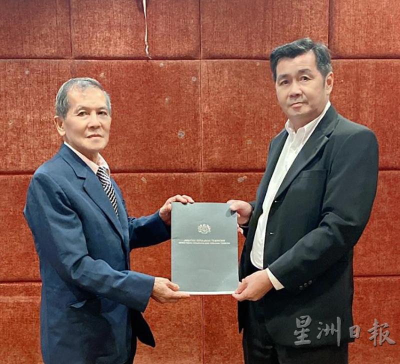 梁汉强(左)领取委任状。