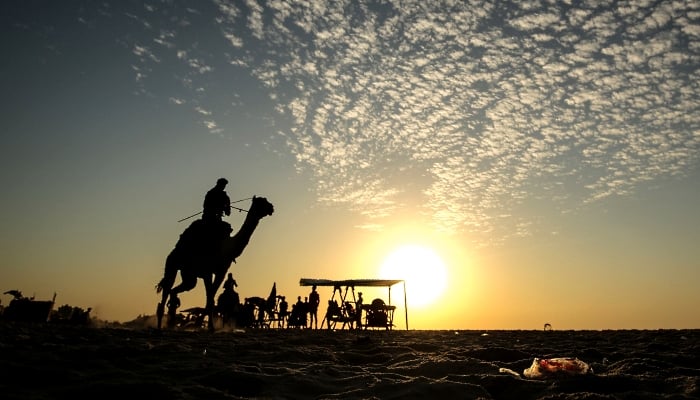 A Palestinian man rides a camel at a beach in Gaza City. AFP