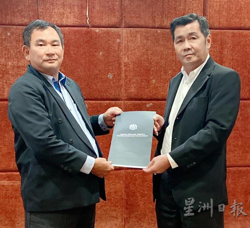 杨汉振(左)从房屋及地方政府部新村协调官蔡同财(右)手中领取委任状。