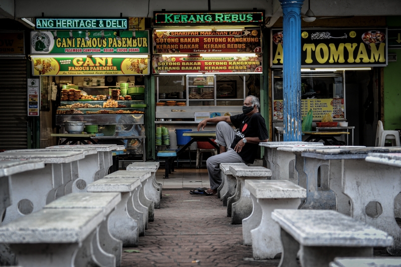 在槟城旧关仔角，业者望著空荡荡的桌子，只能无语问苍天。