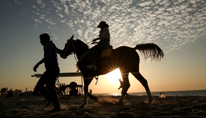 Palestinians ride horses on the beach in Gaza City. AFP