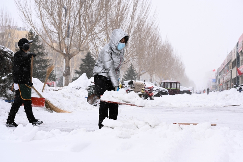 11月19日内蒙古东部降雪持续，赤峰市敖汉旗新惠镇居民自发清理路面积雪。　

