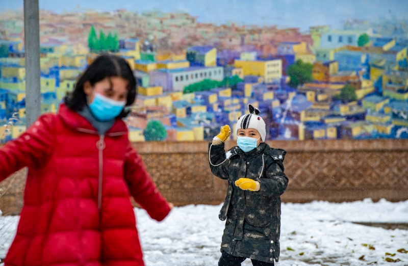 11月21日，小朋友在喀什古城景区内玩雪。


