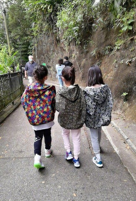 黎姿的3个女儿穿着碎花风衣，身高相仿。

