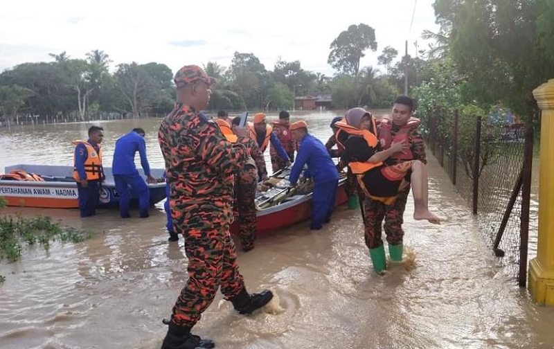 消拯人员抱起村民逃离水灾场。