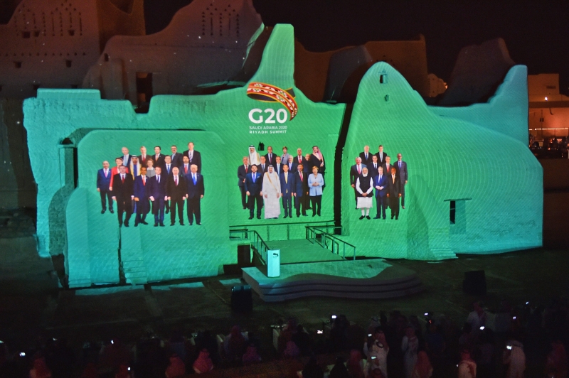在沙地首都利雅得拉开帷幕的G20峰会因冠病疫情而改为线上举行，图为G20领袖“全家福”投射在利雅得郊区的一个历史古迹。（法新社照片）