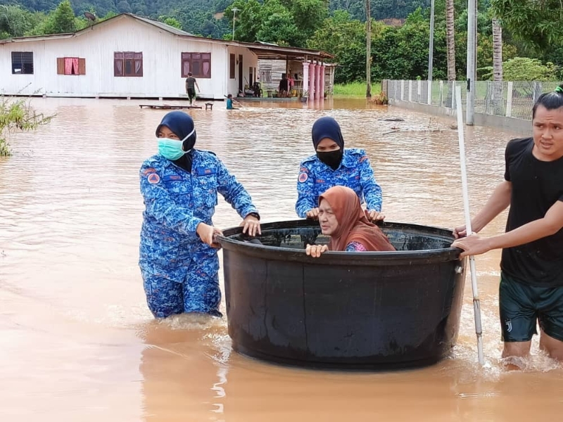 勿述民防部队队员用大水盆把一名老妇从淹水的住家就出来，将她送到疏散中心。

