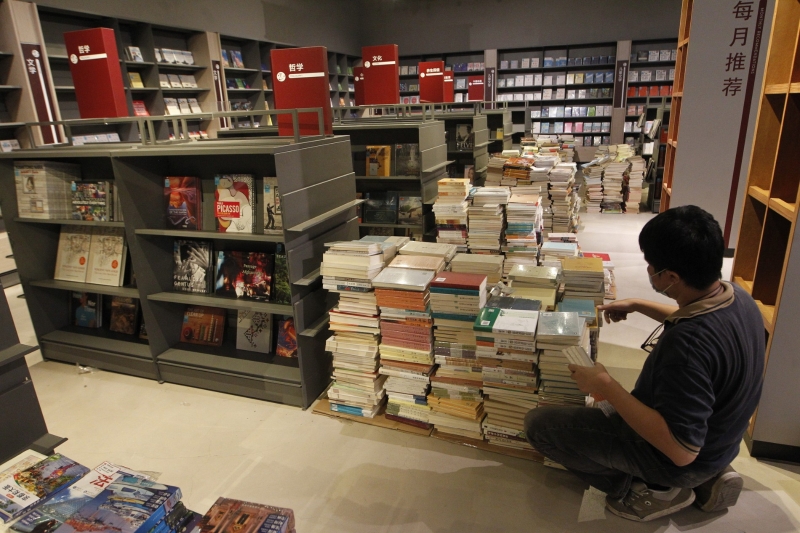 书馆员工在书海中，忙着整理成千上万的各类书籍。