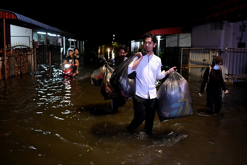 督仄巴的慕尼柏迈花园的居民带着值钱的家当紧急离开已淹水的住家。

