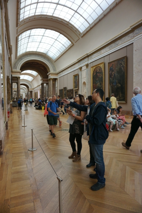 专于美学，亦是博物馆行政推动者的许斗达，在巴黎罗浮宫和团员们分享经验，告诉大家在参观时限内如何看画、怎样消化满满的资讯，创造满载而归的美术馆体验。（许斗达提供）